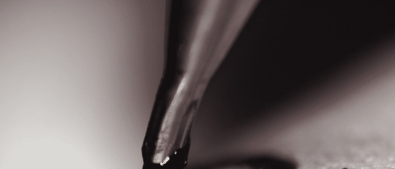 Aiguille de dermographe traçant une ligne d'encre noire sur la peau